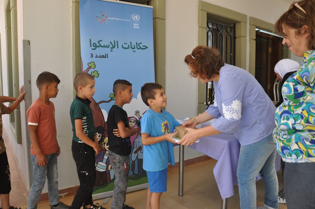 Woman giving book to a child