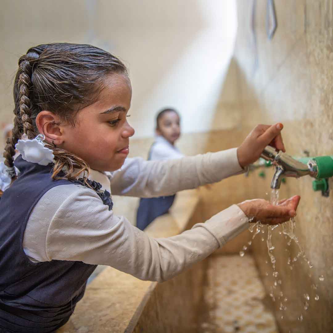 Girl at a water facet in Iraq. Photo: Anmar/Unicef