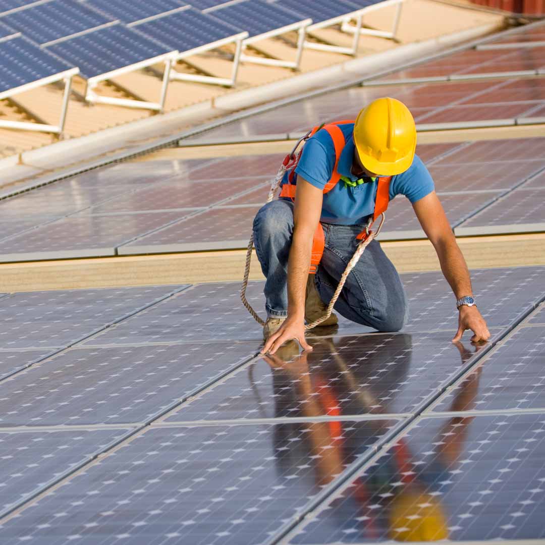 Man installing rooftop solar panels. Photo: iStock