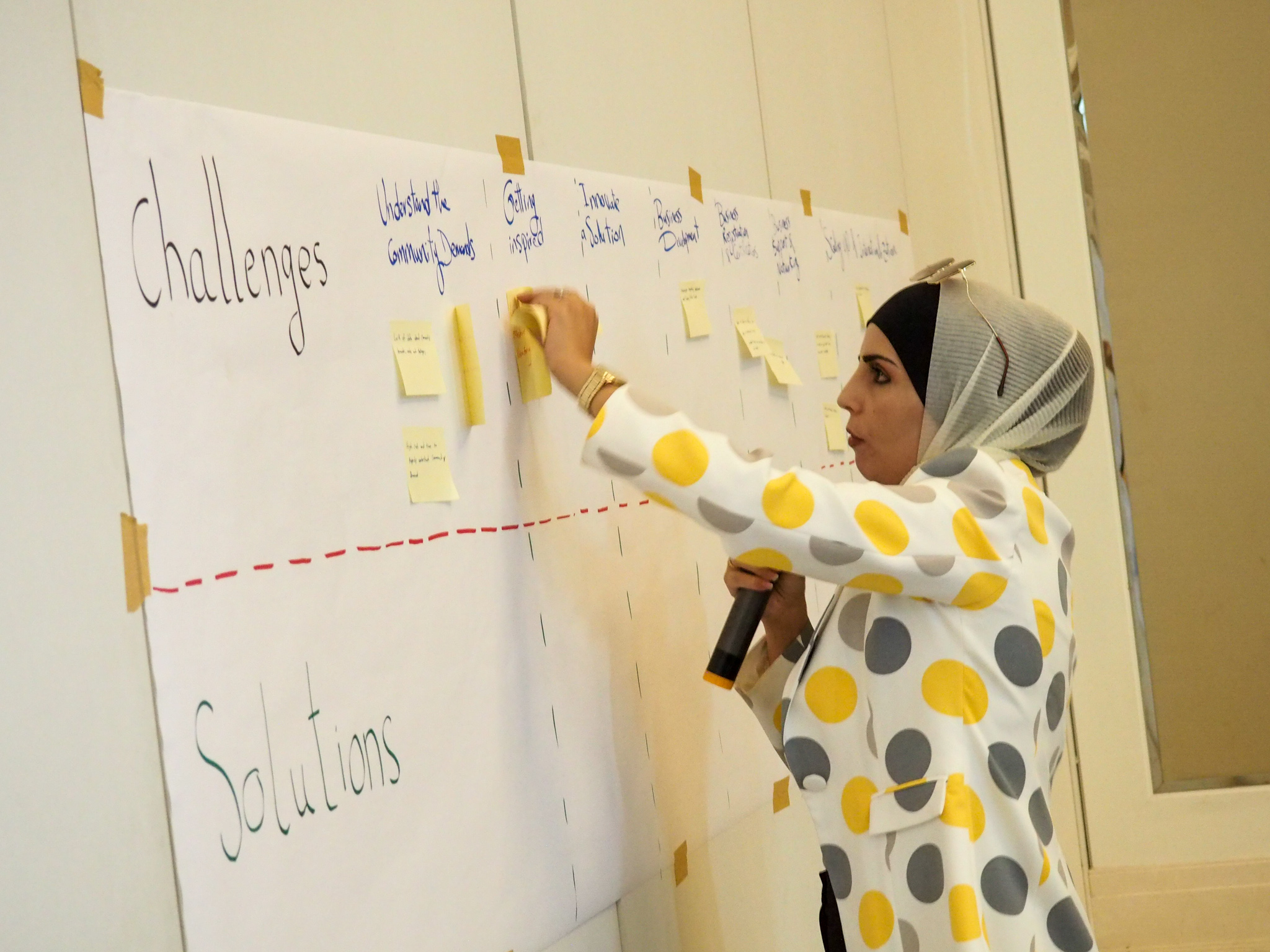 Woman placing sticky notes on board