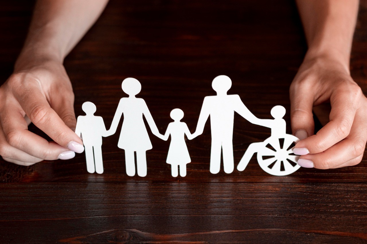 Paper family on wooden background 