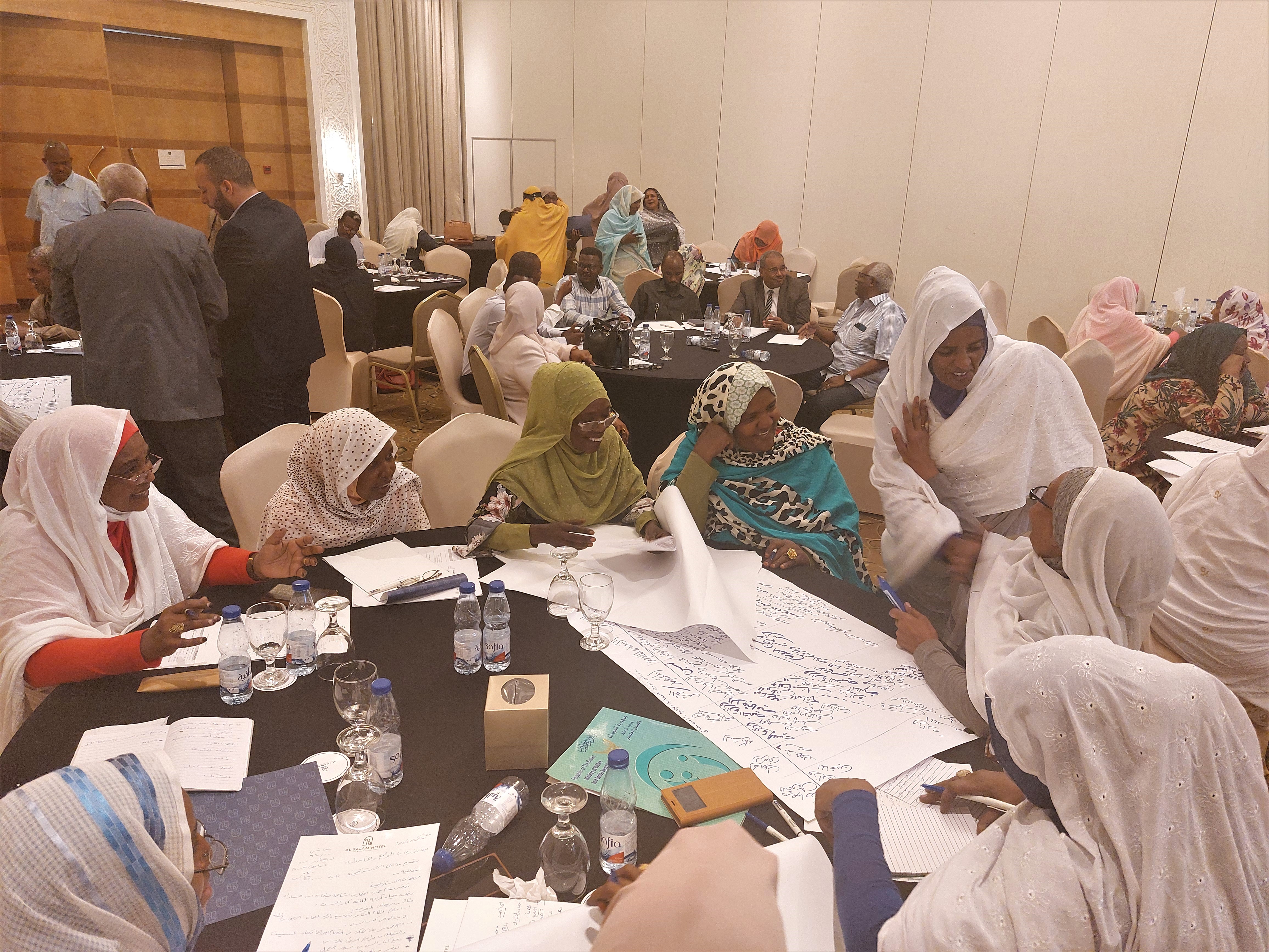 Group of participants around tables in the workshop