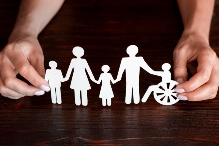 Paper family on wooden background 