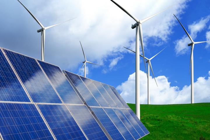 Solar panel seen with wind mills in the background