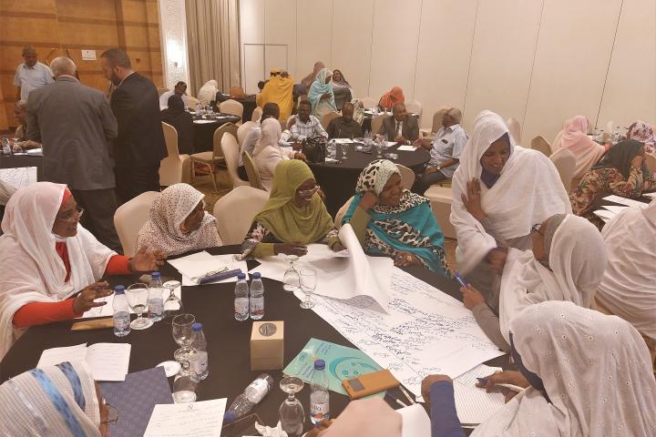 Group of participants around tables in the workshop